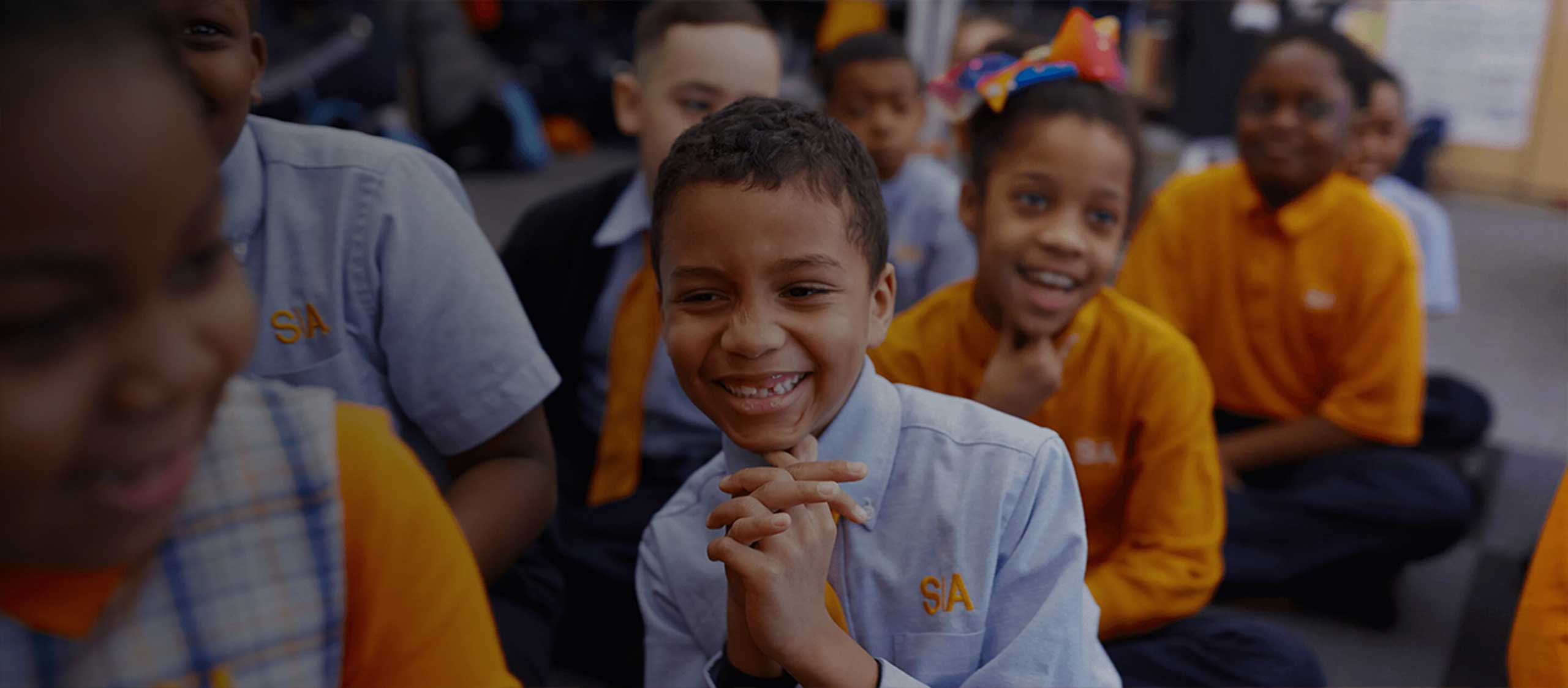 Queens charter school students sitting on the floor for a lesson